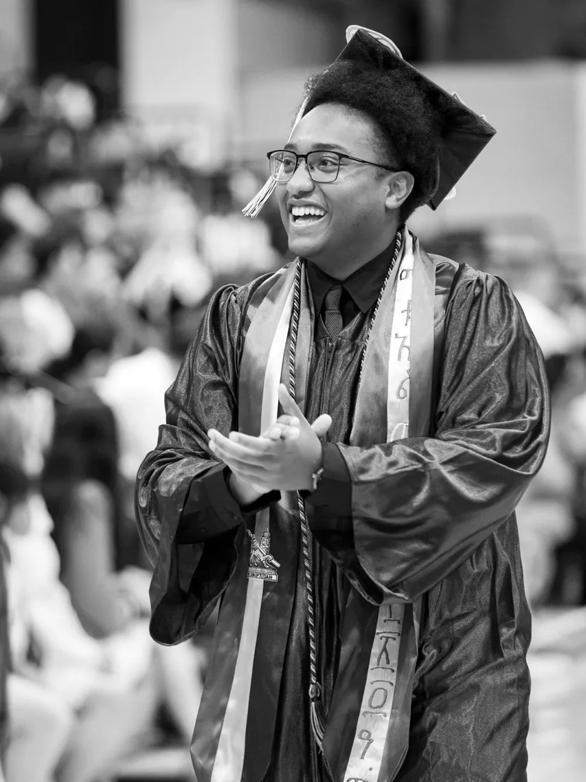 A graduate applauding at commencement