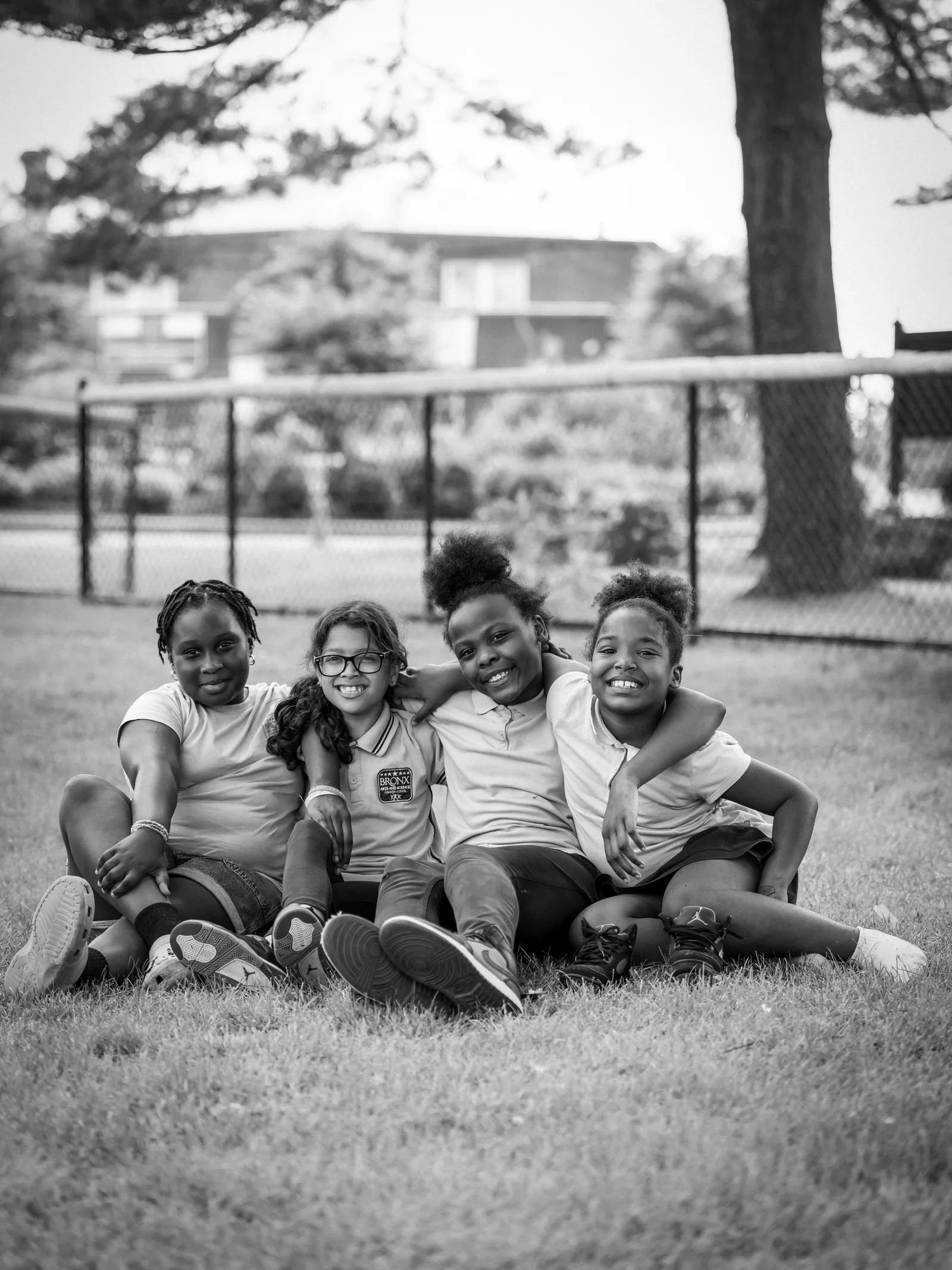 Four students sitting together on the grass outside school